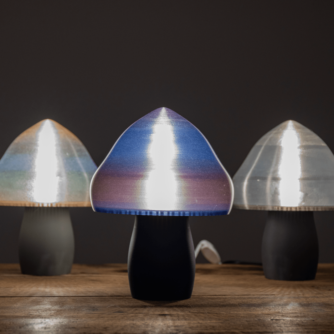 Avec leur chapeau légèrement transparent, ces lampes se déclinent en trois coloris, arc-en-ciel, argenté et dégradés de rose et bleu