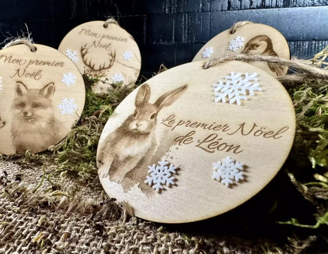 A personalized wooden Christmas ball, it represents a hare with the text Leon's first Christmas. Small white flakes in biodegradable PLA are stuck on it